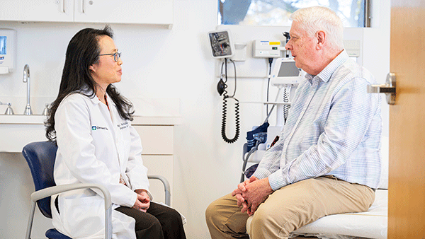 Jennifer Hockings, Pharm D, PhD, talking with a patient during an exam.