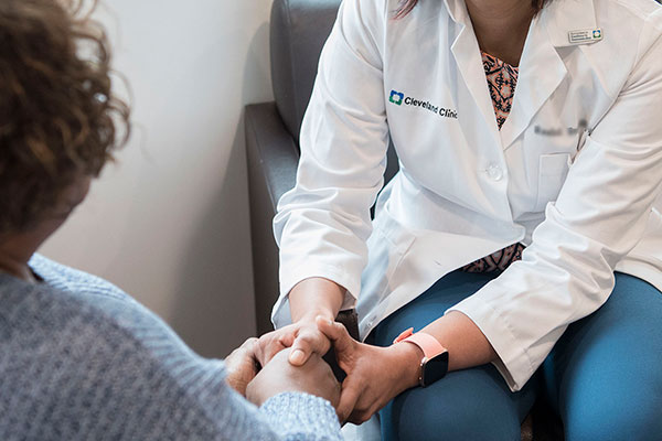 Cleveland Clinic doctor holding a patients hand.