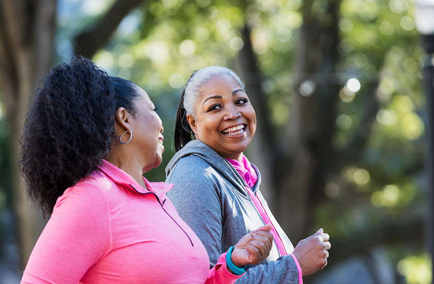 Two women walking outside for healthy exercise.